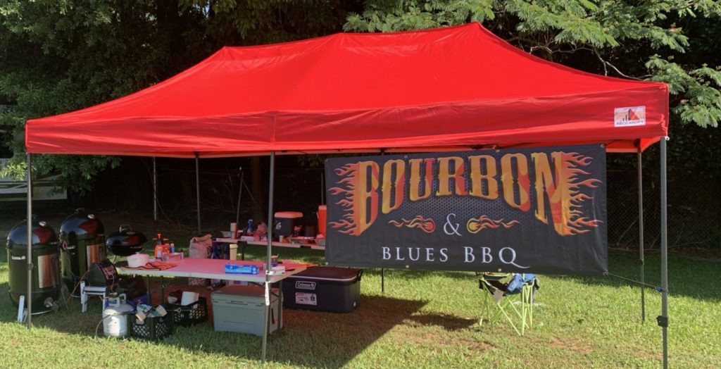 BBQ competition set-up with a tent, smokers, tables and other equipment